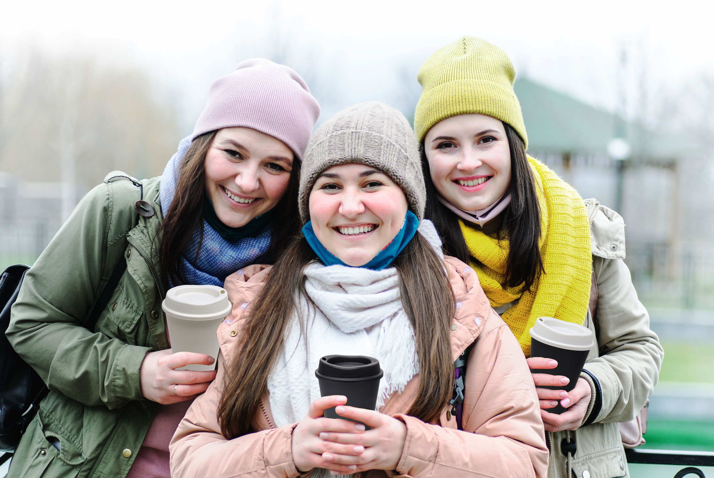 3 young girls drinking from reusable coffee to go cups